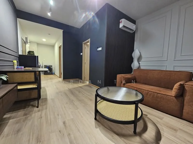 Living features: 3-seater fabric sofa in brown, round coffee table with black frame and rattan surface, wooden TV console, wall-mounted air conditioning unit, light wood flooring, dark accent wall, white panelled wall, decorative wall light, open doorway leading to another room; style: modern.