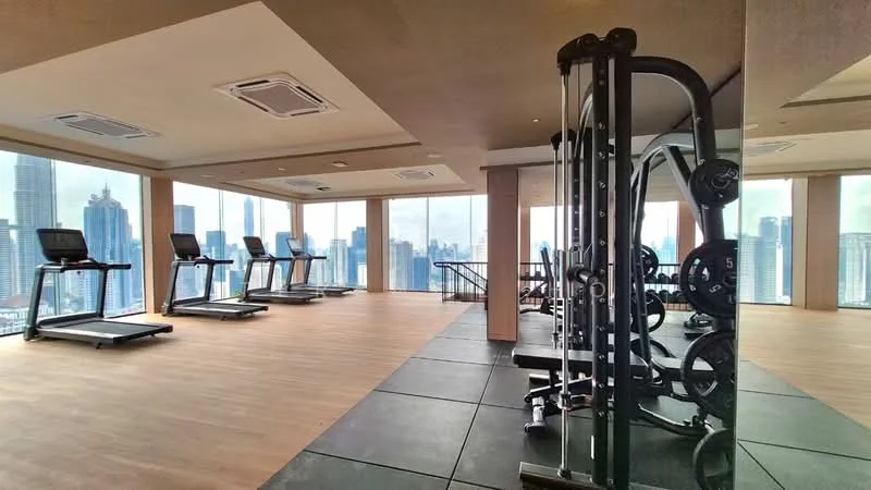 Room features: treadmills, weightlifting equipment, large floor-to-ceiling windows, city skyline view, wooden flooring, black rubber flooring, air conditioning units, mirrored wall, lighting fixtures; style: modern; view: city.