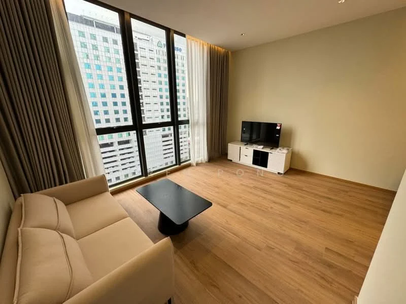 Living features: light brown wooden flooring, floor-to-ceiling windows, sheer curtains, beige fabric sofa, black coffee table, white TV console, wall-mounted TV, decorative wall, city view; style: modern; view: city.