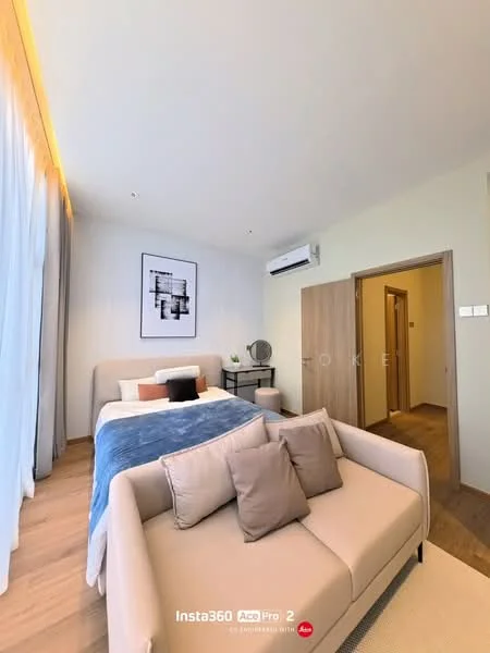Bedroom features: queen-size bed with upholstered headboard, light grey bedding, blue throw blanket, 2 bedside lamps, wooden side table, wall-mounted split AC, large window with sheer curtains, wooden flooring, framed artwork on wall, decorative mirror, sofa in light beige fabric, area rug with geometric pattern; style: modern.
