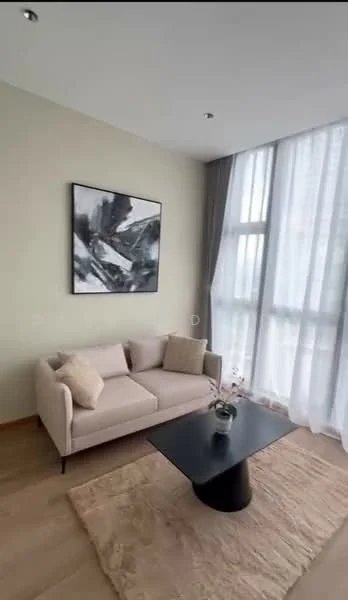 Living features: light beige fabric sofa, black round coffee table, area rug with neutral color, large floor-to-ceiling windows, sheer curtains, framed abstract artwork on wall, wooden flooring, recessed ceiling lights; style: modern.