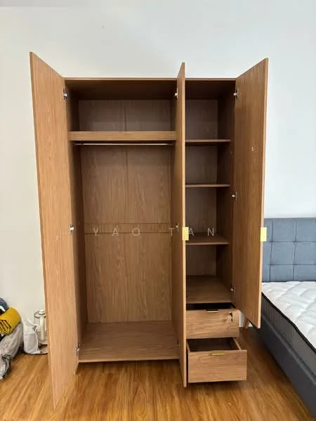 Room features: wooden wardrobe with two doors, open shelving, two drawers at the bottom, light wood finish, hanging space, flooring in light wood, neutral wall color, bed visible in background; style: modern.