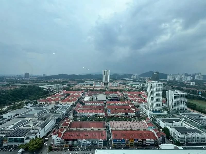 Exterior type: high-rise condominium; features: city skyline view, surrounded by residential buildings, commercial buildings in foreground, greenery in background, cloudy sky, urban landscape; style: modern.