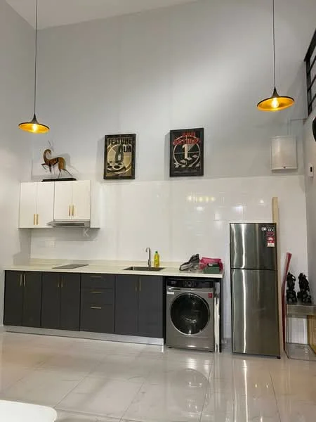 Kitchen features: black cabinetry with white upper cabinets, white countertop, stainless-steel single-bowl sink, chrome pull-down faucet, built-in washing machine, stainless-steel fridge, pendant lighting, wall-mounted artwork, white tiled backsplash, polished tile flooring; style: modern.