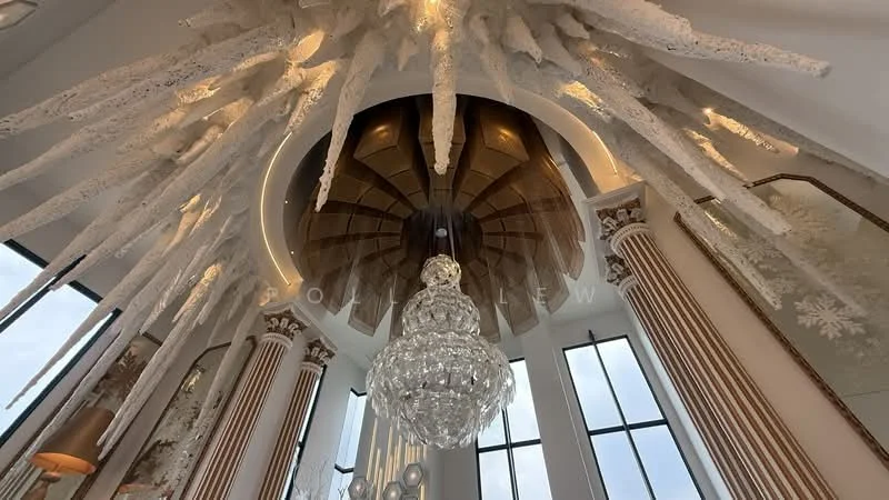 Room features: ornate chandelier, intricate ceiling design, large floor-to-ceiling windows, decorative wall panels, crown moulding, white walls, wooden ceiling with circular design, elegant light fixtures; style: luxury; view: city.