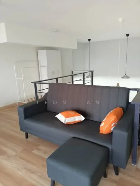 Living features: grey fabric sofa, orange decorative pillows, wooden flooring, open layout, metal railing, recessed ceiling lights, white walls, small ottoman; style: modern.