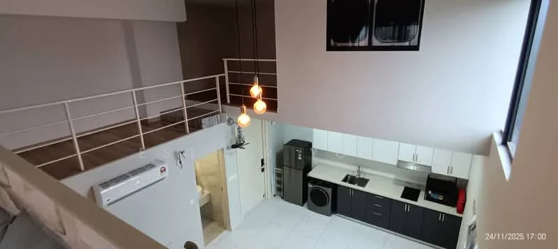 Kitchen features: white cabinetry, black countertop, stainless-steel fridge, built-in oven, freestanding washing machine, single-bowl stainless-steel sink, chrome pull-down faucet, ceramic tile flooring, recessed downlights, 1 wall-mounted split AC; style: modern. Living features: open layout, wood flooring, 2 pendant lights, railings, high ceiling; style: modern.