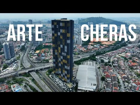 Exterior type: high-rise condominium; features: glass curtain wall, yellow and grey facade, recessed balconies, surrounded by urban landscape, adjacent to highway, multi-storey car park, commercial space at ground level; style: modern.