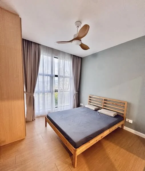 Bedroom features: queen-size bed, wooden bed frame, two decorative pillows, floor-to-ceiling windows, sheer curtains, wooden flooring, ceiling fan with 3 blades, light green accent wall, built-in wardrobe, natural light from window; style: modern; view: garden.