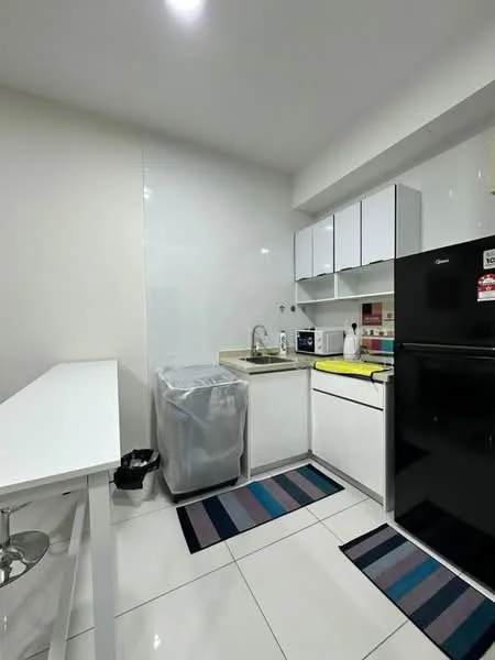 Kitchen features: white cabinetry, black refrigerator, microwave, single-bowl stainless-steel sink, chrome pull-down faucet, countertop with light-colored surface, white tiled backsplash, ceramic tile flooring, two area rugs with striped pattern, bar counter with stools, waste bin, kitchen appliances, under-cabinet lighting; style: modern.