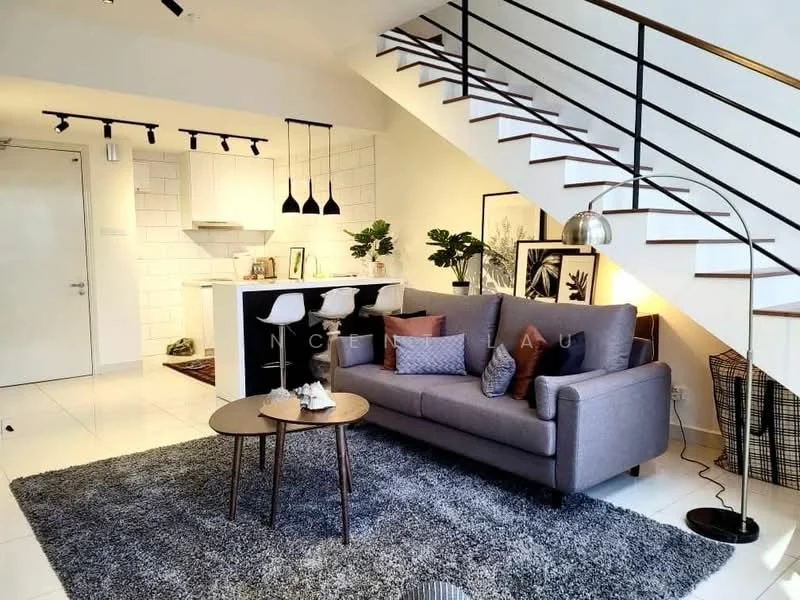 Living features: grey fabric sofa, coffee table with wooden legs, area rug with geometric pattern, pendant lighting with three black shades, floor lamp with arc design, wall-mounted artwork, potted plants, open shelving unit, staircase with black railing, white tiled flooring, white walls, kitchenette with white cabinetry; style: modern.