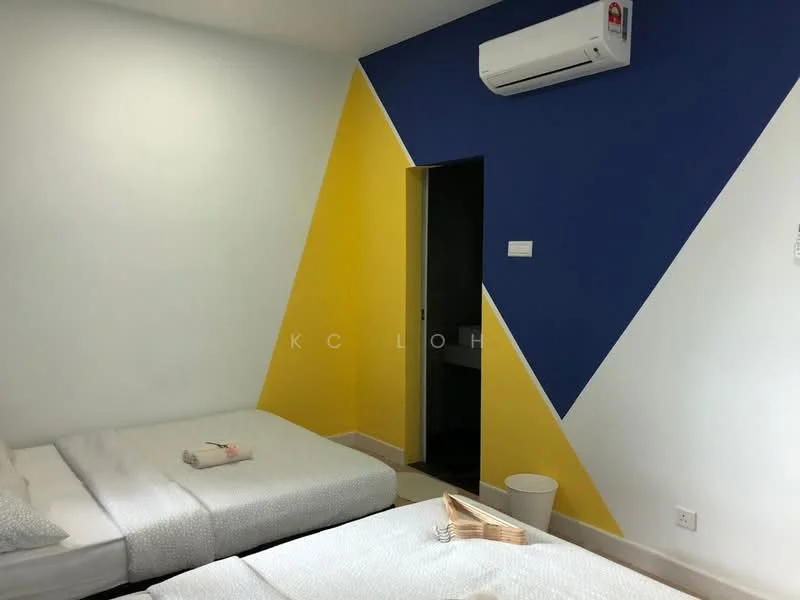 Room features: two single beds with white bedding, blue and yellow accent wall, white painted walls, air conditioning unit on wall, doorway leading to another room, tile flooring, waste bin, decorative wooden tray; style: modern.