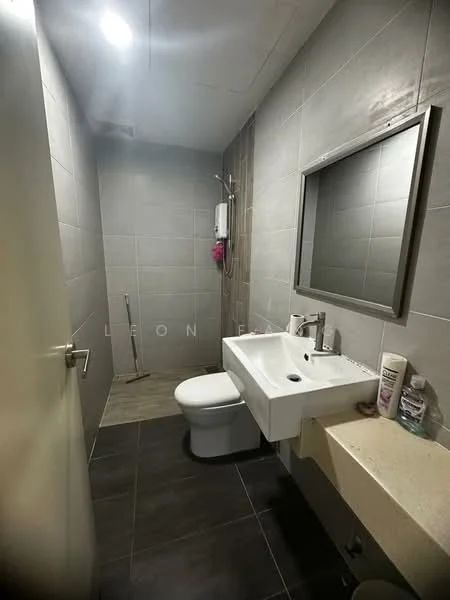 Bathroom features: grey tiled walls, dark grey tiled flooring, white wall-mounted sink, chrome basin mixer faucet, framed mirror, one-piece toilet, shower with wall-mounted showerhead, soap dispenser, toilet paper holder, pink shower caddy; style: modern.