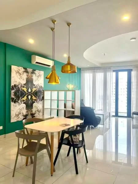 Dining features: white dining table, 4 wooden dining chairs, gold pendant lights, green accent wall, large abstract artwork, floor-to-ceiling windows, sliding glass door, white ceramic tile flooring, wall-mounted split AC; style: modern; view: city. Living features: black armchair, open shelving unit, decorative items on shelves, natural light from windows; style: modern; view: city.