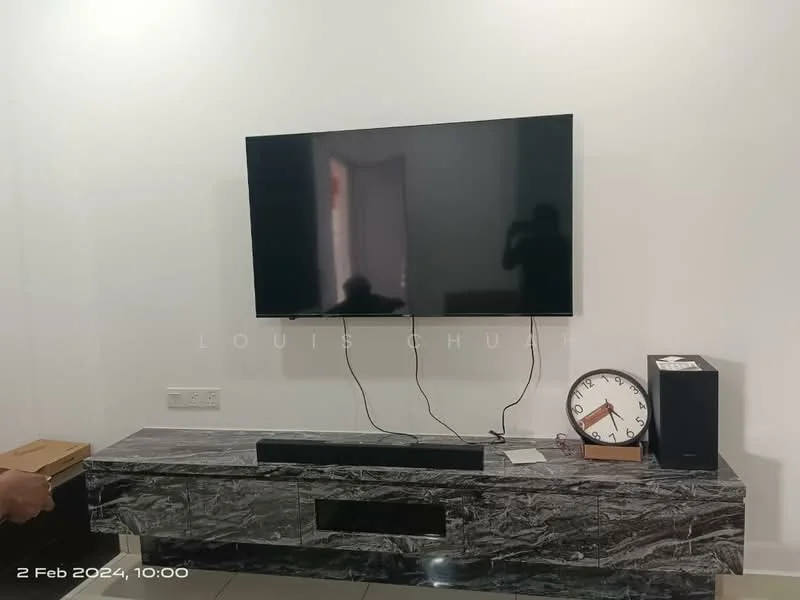Living features: wall-mounted flat-screen TV, black soundbar, grey marble TV console, white painted walls, floor tiles, clock on console, cable management visible; style: modern.