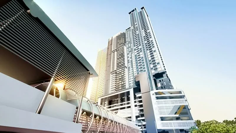 Exterior type: high-rise condominium; features: glass curtain wall, projecting balconies, exposed concrete facade, multiple storeys, parking deck visible, surrounded by greenery; style: modern.