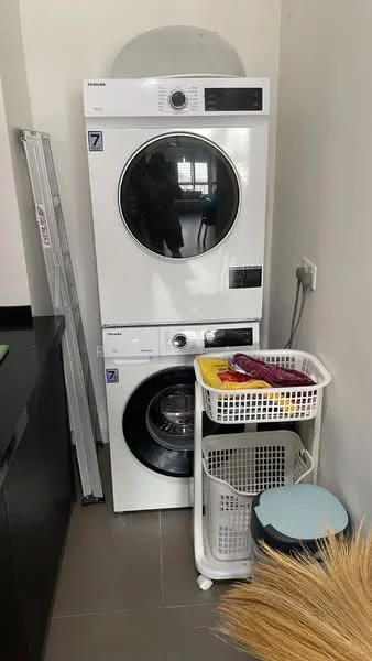 Laundry features: stacked washer and dryer, white appliances, laundry basket, grey tiled flooring, white wall, black countertop, sliding door, storage shelf; style: modern.