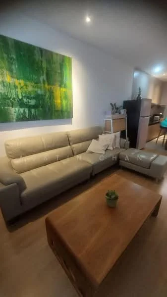 Living features: 3-seater fabric sofa in beige, wood coffee table, abstract wall art with green and yellow tones, recessed downlights, laminate flooring, decorative plant on coffee table, built-in cabinetry in background; style: modern.