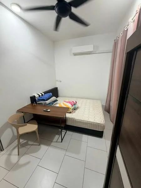 Bedroom features: white painted walls, tile flooring, ceiling fan, wall-mounted split AC, single bed with mattress, wooden desk, chair, bedside table, pink curtains, bedding with colorful patterns.