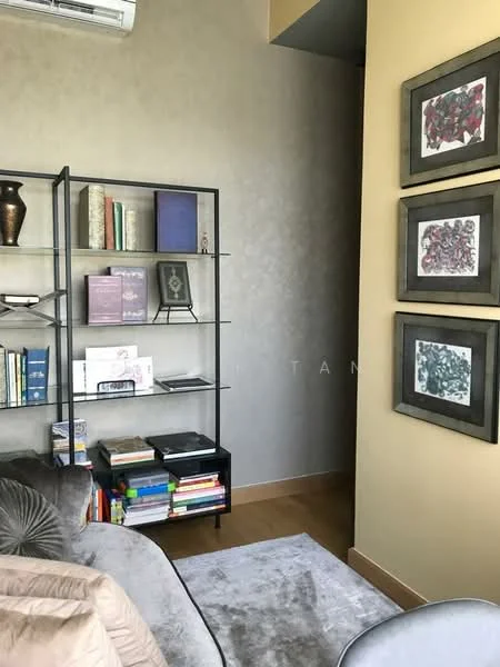 Study features: grey accent wall, wood flooring, metal shelving unit, books on shelves, decorative vases, framed artwork on walls, sofa with cushions, natural light from window; style: modern.