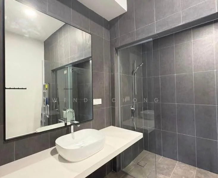 Bathroom features: grey tiled walls, grey tiled flooring, large wall-mounted mirror, single-bowl ceramic sink, chrome basin mixer faucet, walk-in shower with glass enclosure, rain shower head, handheld shower, shower floor drain, wall-mounted towel rack; style: modern.