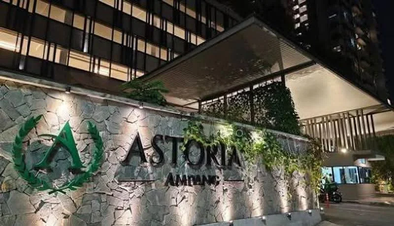Exterior type: high-rise condominium; features: stone cladding facade, illuminated signage, landscaped greenery, covered entrance, modern architectural design, night lighting, glass curtain wall, manicured plants; style: contemporary.