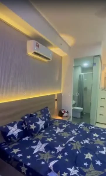 Bedroom features: queen-size bed with star-patterned bedding, wooden headboard, wall-mounted air conditioning unit, recessed LED lighting, light grey accent wall, nightstand with lamp, built-in wardrobe, carpet flooring, en-suite bathroom visible, decorative wall paneling; style: modern. Bathroom features: shower curtain, toilet, sink with cabinet, tile flooring, mirror, light fixture.