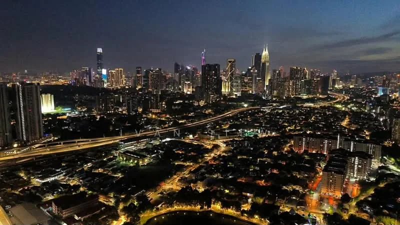 Exterior features: city skyline view, nighttime lighting, high-rise buildings, urban landscape, main road, surrounded by greenery; style: modern.