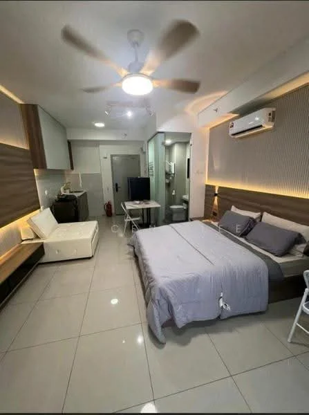 Room features: grey bedding, queen-size bed, upholstered headboard, 2 bedside tables, white wall-mounted TV, white sofa, ceiling fan with light, wall-mounted air conditioning unit, recessed lighting, grey tiled flooring, built-in cabinetry, open shelving, dining table with chairs, glass partition to bathroom, bathroom door visible; style: modern.
