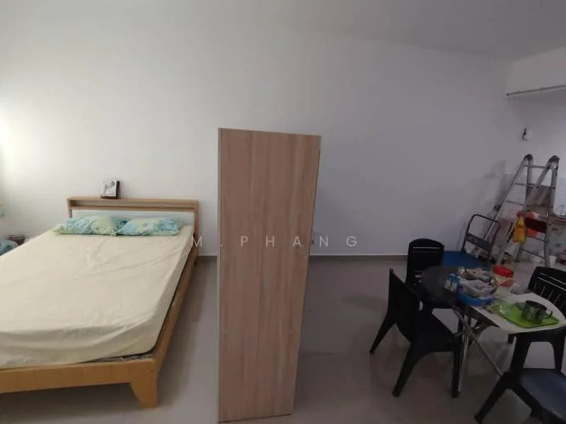 Room features: queen-size bed with light bedding, wooden bed frame, light-coloured walls, tile flooring, wooden wardrobe, dining table with chairs, kitchen utensils on table, step ladder in background; style: minimalist.