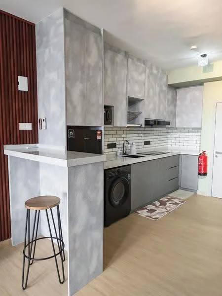 Kitchen features: grey textured cabinetry, white subway tile backsplash, stainless-steel sink, chrome pull-down faucet, built-in oven, black refrigerator, front-load washing machine, countertop with bar seating, stool with metal legs, light wood flooring, fire extinguisher mounted on wall, area rug with geometric pattern; style: modern.