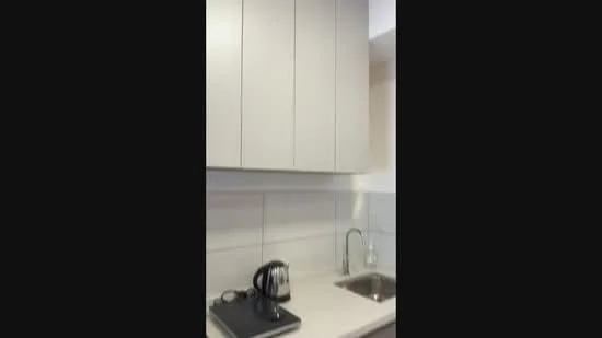 Kitchen features: light grey cabinetry, single-bowl stainless-steel sink, chrome faucet, white countertop, white tiled backsplash, kettle, built-in appliances, under-cabinet lighting; style: modern.