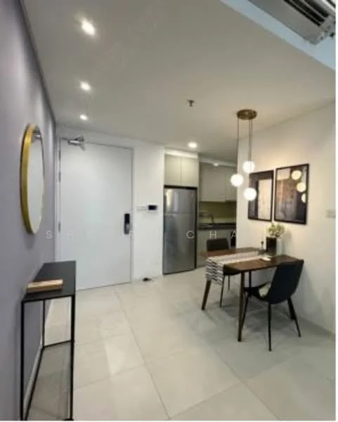 Dining features: round dining table, upholstered dining chairs, pendant lighting with multiple bulbs, wall-mounted mirror, grey accent wall, white walls, tile flooring, refrigerator, entrance door, decorative wall art; style: modern. Kitchen features: stainless-steel fridge, white cabinetry, countertop, kitchen appliances visible; style: modern.