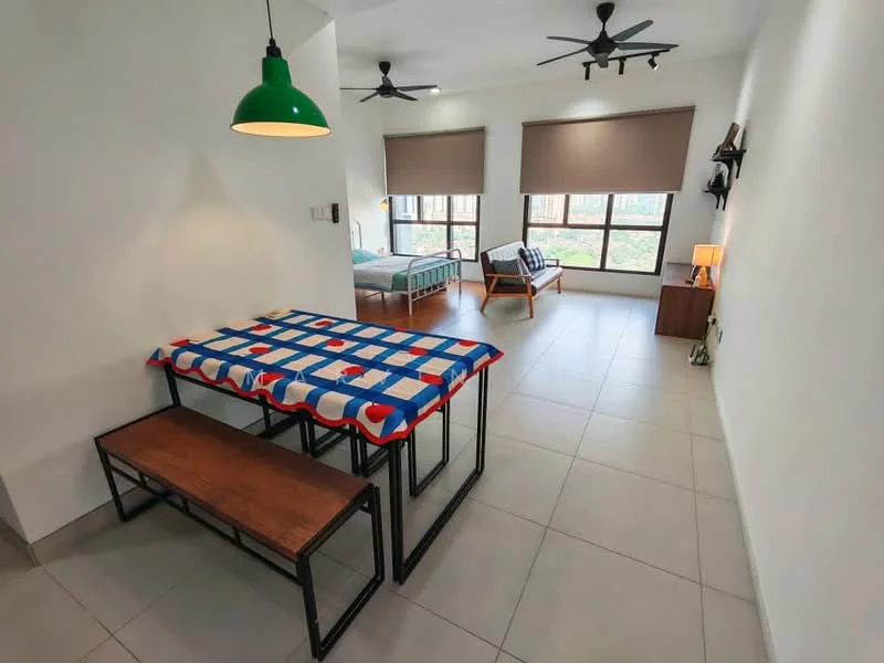 Room features: white painted walls, grey tiled flooring, 5-blade ceiling fan, 5-blade ceiling fan, large windows with roller blinds, dining table with blue and red tablecloth, wooden bench seating, armchair, bed with green frame, lamp on bedside table; style: modern; view: garden.