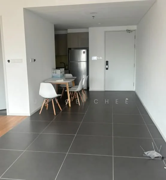 Room features: grey tile flooring, white painted walls, dining table with four white chairs, stainless-steel fridge, door leading to another room, light fixture on ceiling, open layout, kitchen area visible in background; style: modern.