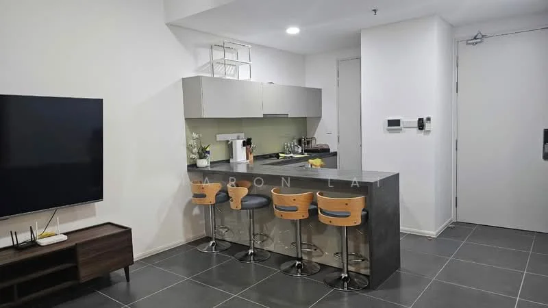 Kitchen features: grey cabinetry, white countertop, stainless-steel sink, chrome pull-down faucet, bar counter with 3 stools, built-in appliances, wall-mounted TV, tile flooring, recessed lighting; style: modern.