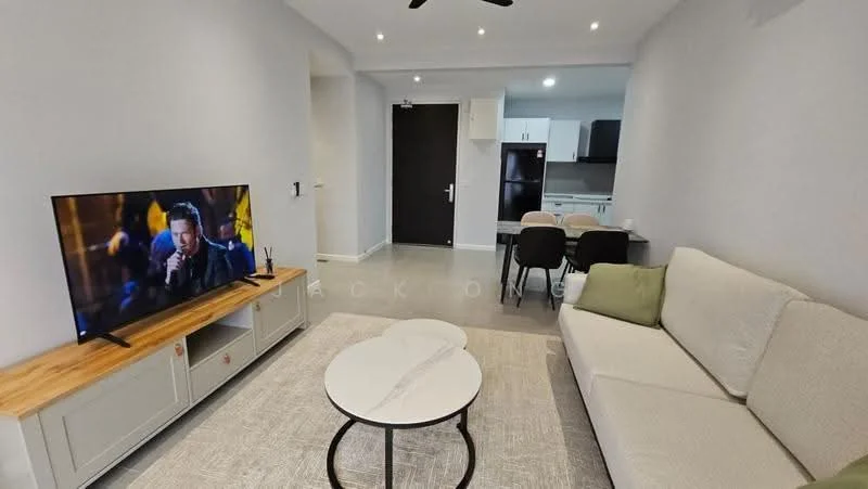 Living features: 3-seater fabric sofa in white, coffee table with round top, TV console with wooden surface, wall-mounted TV, recessed downlights, ceiling fan, light grey painted walls, textured flooring, open layout to kitchen, dining area visible in background; style: modern.