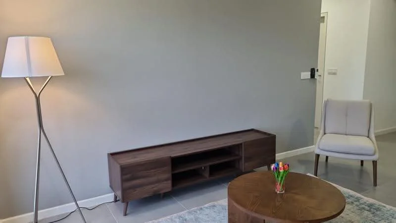 Living features: light grey painted walls, tile flooring, floor lamp with white shade, wooden TV console, coffee table, upholstered armchair in light fabric, decorative vase with flowers, area rug; style: modern.