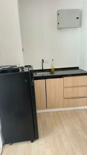 Kitchen features: black countertop, wood cabinetry with light finish, single-bowl stainless-steel sink, chrome faucet, black fridge, wall-mounted electrical panel, laminate flooring, open shelving; style: modern.