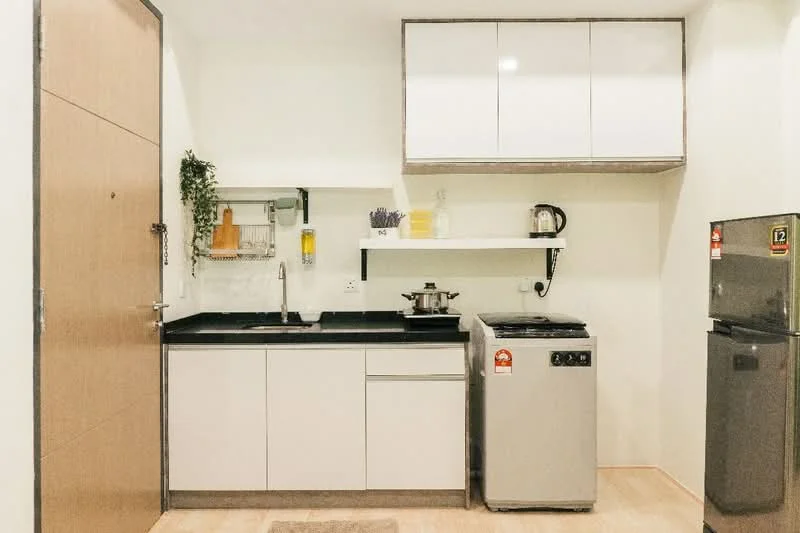Kitchen features: white cabinetry with flat-panel doors, black countertop, single-bowl stainless-steel sink, chrome pull-down faucet, built-in stove, microwave, refrigerator, washing machine, open shelving, wall-mounted plant holder, wooden flooring, light-colored walls; style: modern.