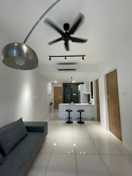 Living features: grey fabric sofa, white painted walls, glossy white tile flooring, 5-blade ceiling fan with integrated LED light, track lighting, open-plan layout to kitchen, bar stools at kitchen counter, air conditioning unit on ceiling; style: modern. Kitchen features: white cabinetry, black countertop, built-in oven, stainless-steel sink, chrome pull-down faucet, refrigerator, kitchen island, bar counter; style: modern.