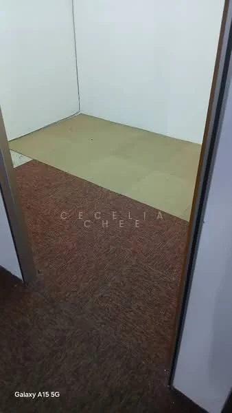 Room features: carpet flooring in brown, plain white walls, vinyl flooring in beige, doorway leading to another room.
