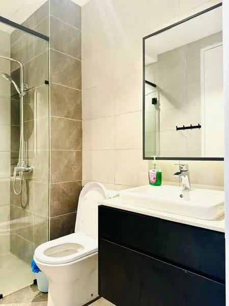 Bathroom features: walk-in shower with glass enclosure, chrome handheld shower, single-sink vanity with black cabinet, white ceramic toilet, framed mirror, grey tile walls, light grey tile flooring, wall-mounted towel rack, liquid soap dispenser; style: modern.