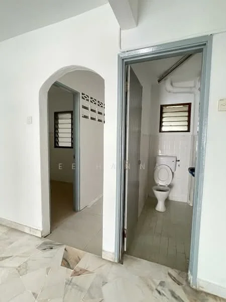 Room features: white painted walls, marble flooring, arched doorway, window with horizontal slats, toilet, sink, light fixture, neutral color scheme; style: minimalist.