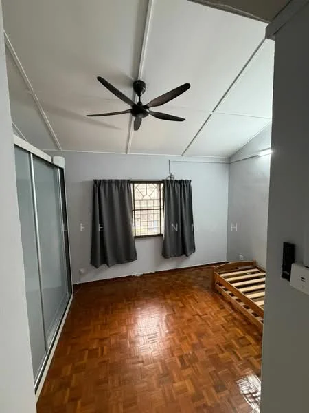 Bedroom features: wooden flooring, grey painted walls, 5-blade ceiling fan, window with grid pattern, curtains in dark grey, sliding glass wardrobe, bed frame without mattress, exposed ceiling beams.
