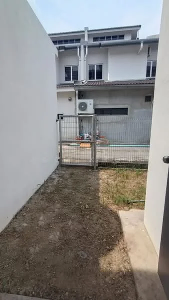 Exterior type: semi-detached house; features: fenced yard, concrete pathway, wall-mounted split AC unit, grass patch, white painted walls, backyard area, visible neighboring house, gated entry; style: modern.