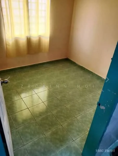 Room features: green ceramic tile flooring, yellow painted walls, single window with sheer curtains, door with metal handle.