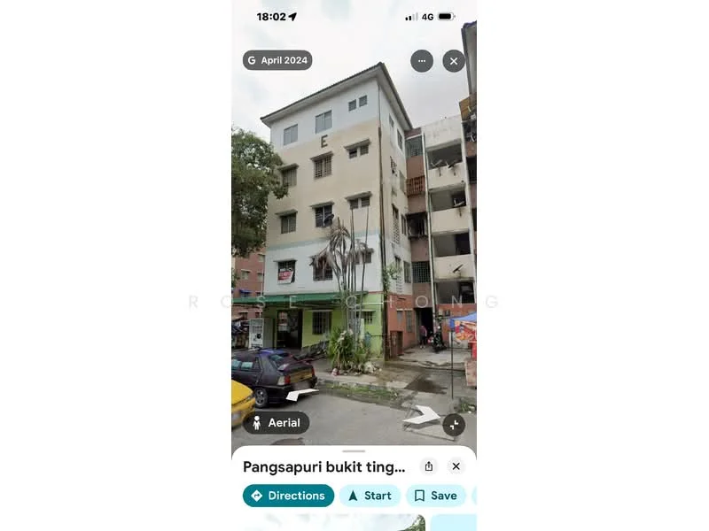 Exterior type: low-rise apartment block; features: 3-storey building, painted facade, balconies on upper floors, palm tree in front, parking area visible, adjacent buildings, urban setting; style: modern.