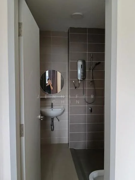 Bathroom features: grey tiled walls, white sink, chrome basin mixer faucet, round mirror, shower with handheld showerhead, wall-mounted shower mixer, toilet, light fixture on ceiling, grey tiled flooring, water heater, sliding door, white painted door; style: modern.