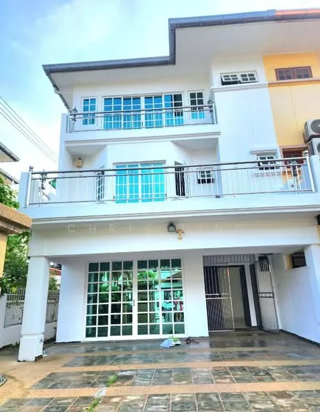 Exterior type: linked terrace house; features: white painted facade, glass sliding doors, balcony with railing, paved walkway, two-storey structure, multiple windows, front garden area, visible air conditioning unit; style: modern.